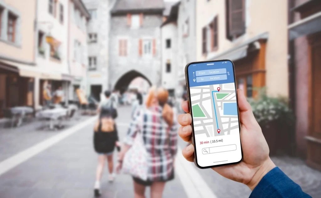 SEO Services for Automotive & Car Dealership – Drive Organic Leads 6 Driver holding a phone showing a local map result on a UK street, the map pack search a garage or forecourt needs to win